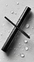 Black Mascara Tube With Brush Positioned on Wet Surface With Water Droplets photo