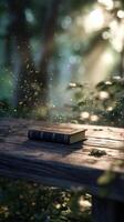 Sunlight Streams Through Lush Leaves, Casting a Warm Glow on an Open Book Placed on a Weathered Wooden Table photo