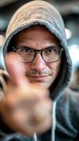 Man in Hoodie Giving Thumbs up Gesture With Confident Expression in a Modern Indoor Setting photo