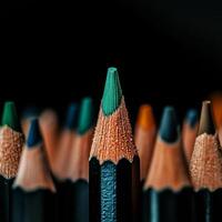 Green Pencil Tip Stands out Among Colorful Sharpened Pencils in Dark Background. photo