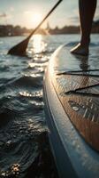 Sunset Paddleboarding on Calm Waters With Reflections in the Evening. photo