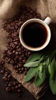 Coffee Cup Surrounded by Roasted Beans and Green Leaves on Burlap Fabric. photo
