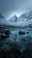 Mountain Range Reflected in Still Water Under Cloudy Sky During Early Morning in a Remote Wilderness photo