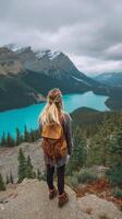 Woman Enjoying a Breathtaking View of Turquoise Lake and Mountains in National Park During Cloudy Weather photo