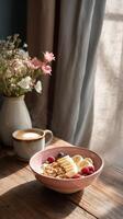 Delicious Breakfast Bowl With Fruits and Coffee on a Wooden Table in Morning Light. photo