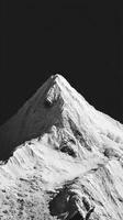 Majestic Snow-Covered Peak Surrounded by Dark Sky at High Altitude During Winter Season photo