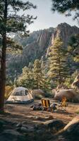 Serene Camping Spot in Rocky Mountains Surrounded by Tall Trees During Golden Hour photo