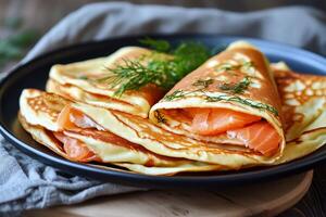 Delicious Crepes Filled With Smoked Salmon and Herbs on a Rustic Wooden Table photo