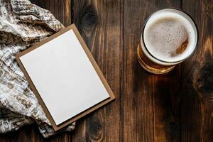 Craft Beer Served in a Glass Next to a Blank Paper on Wooden Table With Wheat. photo