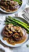 Delicious Steak With Mushroom Sauce Served With Asparagus on a Light Grey Table photo