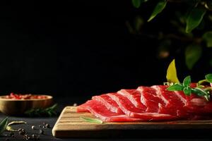 Freshly Sliced Meat Rests on a Wooden Board Garnished With Herbs and Spices in a Dim Setting photo