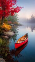 Canoe Resting on Calm Lake Surrounded by Vibrant Autumn Foliage in Early Morning Mist photo