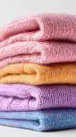 Colorful Knitted Sweaters Stacked Neatly for a Cozy Display on a Light Background photo