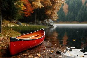 Red Canoe on a Tranquil Lake Surrounded by Autumn Trees During Rain in a Mountainous Region. photo