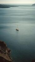 Sailboat Floats Peacefully on Calm Waters Near Cliffs at Sunset in Santorini photo