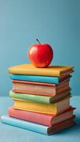 Stacked Colorful Books With a Red Apple Placed on Top for a Creative Learning Concept photo