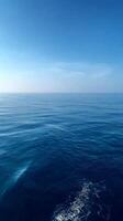 Calm Ocean Surface Under a Clear Blue Sky on a Serene Day by the Coast. photo