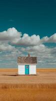 White House With Turquoise Door in Golden Field Under Blue Sky With Clouds. photo
