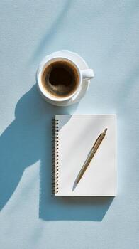Writing in a Notebook With a Cup of Coffee on a Light Blue Table. photo