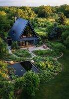 Charming Modern Cabin Surrounded by Vibrant Greenery and Peaceful Pond During Golden Hour photo