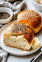 Freshly Baked Bread Rolls Topped With Sesame Seeds Served on a Plate photo