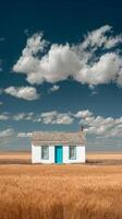 White House With Turquoise Door in Golden Field Under Blue Sky With Clouds photo