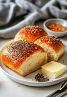 Freshly Baked Bread Rolls Topped With Sesame Seeds Served on a Plate. photo