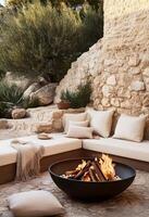 Cozy Outdoor Fireplace Setting With Modern Seating and Natural Stone Wall Near Greenery photo