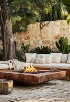 Cozy Outdoor Fireplace Setting With Modern Seating and Natural Stone Wall Near Greenery. photo