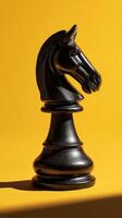 Black Chess Knight Piece on Vibrant Yellow Background Showcasing Unique Design and Shadow Details. photo
