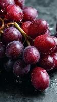 Fresh Red Grapes Glistening With Water Droplets on a Dark Surface. photo