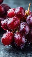 Fresh Red Grapes Glistening With Water Droplets on a Dark Surface photo