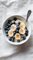 Healthy Breakfast Bowl With Yogurt, Bananas, Blueberries, and Chia Seeds Served in a White Bowl. photo