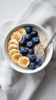 Healthy Bowl of Oatmeal Topped With Fresh Blueberries and Banana Slices for Breakfast photo