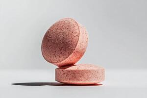 Round Pink Tablets Placed on a White Surface With Soft Shadows in Bright Natural Light photo