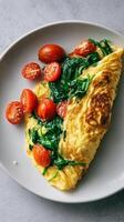 Delicious Spinach and Tomato Omelet Served on a White Plate for Breakfast photo