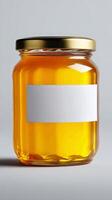 Bright Orange Honey in a Glass Jar With a Gold Lid Against a Simple Background. photo