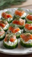 Cucumber Rounds Topped With Cream Cheese and Smoked Salmon Garnished With Fresh Dill at a Food Gathering. photo