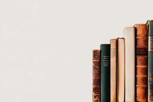 Classic Books Lined up on a Shelf With a Minimalist Background photo