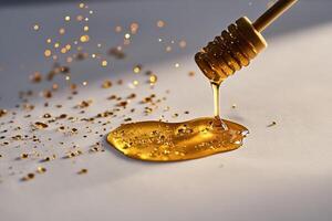 Golden Honey Dripping From a Honey Dipper on a Smooth Surface With Sparkling Particles in Soft Light photo