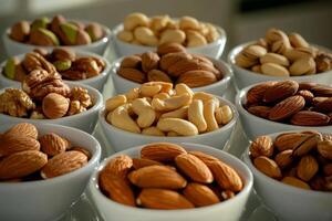 Variety of Nuts Displayed in White Bowls on a Neutral Background for a Healthy Snack Option. photo