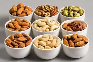 Variety of Nuts Displayed in White Bowls on a Neutral Background for a Healthy Snack Option photo