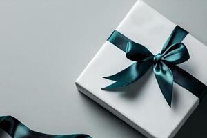 Elegant Gift Box With Teal Ribbon on a Smooth Grey Surface Showcasing Perfect Wrapping photo