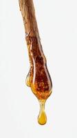 Honey Dripping From a Wooden Stick in a Bright Setting Showcasing Natural Sweetness photo