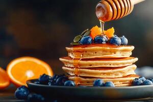 Stack of Pancakes Topped With Blueberries and Honey Drizzled in a Warm Kitchen Setting photo