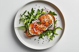 Delicious Smoked Salmon Toast Topped With Fresh Arugula and Onions Served on a White Plate photo