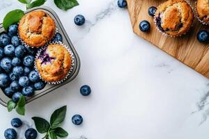 Freshly Baked Blueberry Muffins Arranged in a Metal Tray With Fresh Blueberries Scattered Around. photo