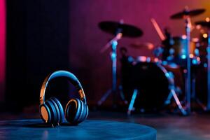 Stylish Headphones Float Near a Vibrant Drum Set in a Music Studio. photo
