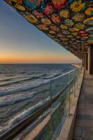 A colorful canopy over the ocean at sunset photo