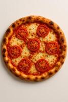 A pizza with tomatoes on top on a white surface photo